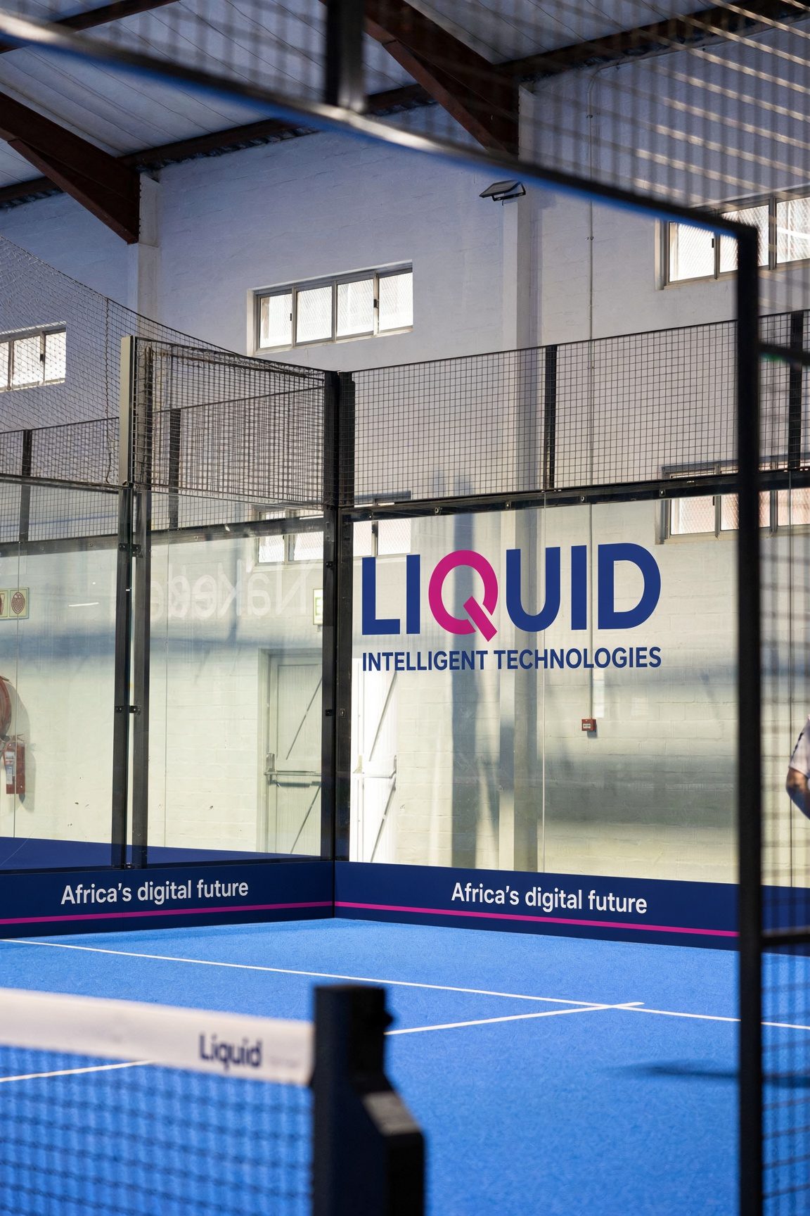 Sponsor mark on the glass of an indoor padel court